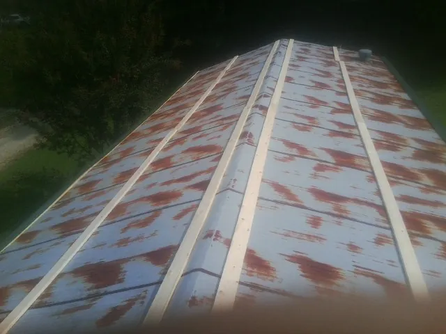 Rusted metal roof panels with new wood purlins before replacement — Storm Damage Roof Repair in Citra by Roofing Brothers
